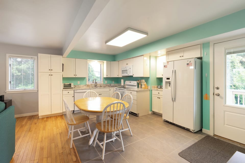Bright, cheerful kitchen with fresh turquoise walls and cream cabinetry invites you to cook and gather. Full appliances, cozy dining nook, and natural light make meal prep a joy.