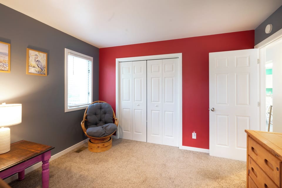Unwind in your private retreat with vibrant accent walls, a cozy swivel chair, and generous closet space to settle in and feel truly at home.