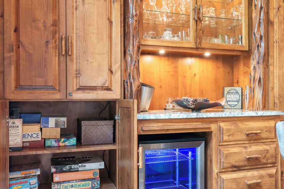 Rustic wooden cabinetry and granite countertops create a cozy bar area, perfect for storing your favorite beverages and enjoying an evening cocktail in the comfort of your retreat.