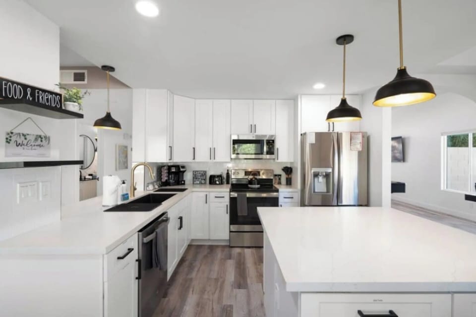 Bright, airy kitchen with island, stainless steel appliances, and abundant counter space.