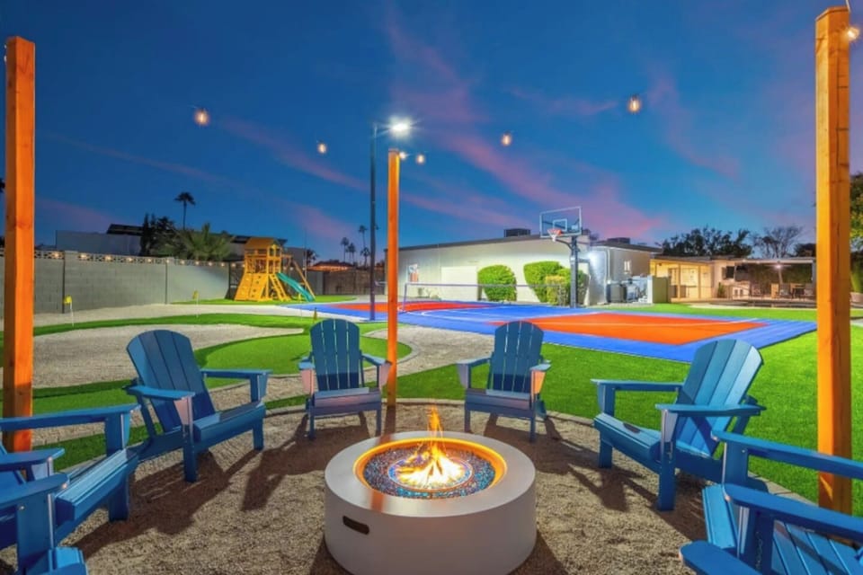 Evening falls and the fire pit lights up, with Adirondack chairs circled up for s'mores and storytelling. Just past the flames, a full sport court and play structure keep the fun going long after the sun sets.
