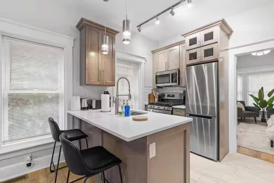 Cook with ease in this stylish kitchen featuring stainless steel appliances, a spacious island, and all the essentials for a comfortable stay.