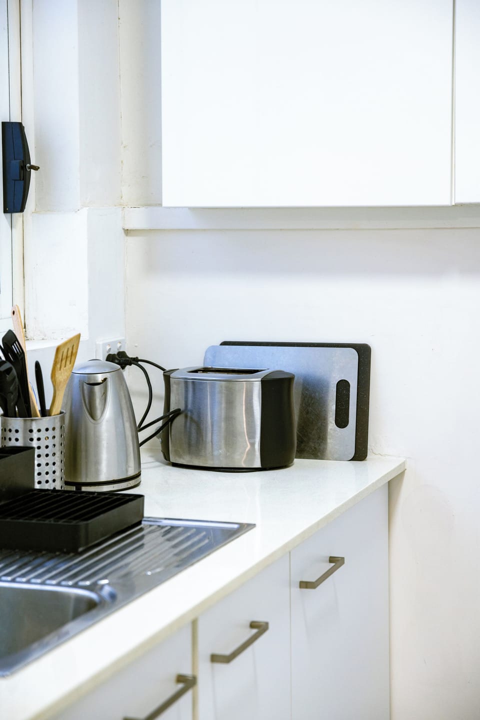 Kitchen counter with kettle, toaster, and cutting board