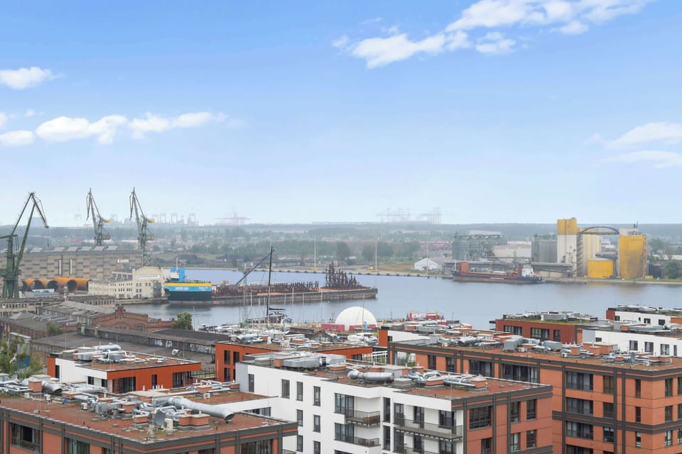 Z salonu można wyjść na umeblowany balkon wyposażony w stół i miejsca do siedzenia. Z 15. piętra rozpościera się panoramiczny widok na Gdańsk, Stare Miasto, tereny stoczniowo-portowe oraz rzekę. 