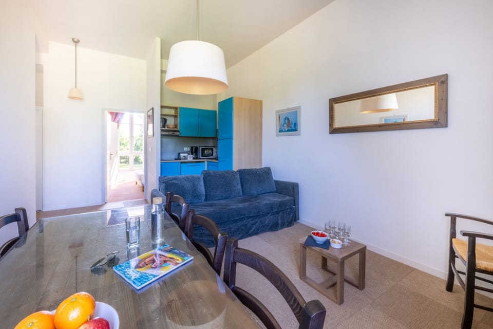 Blue cabinetry lines the kitchenette; pull up a chair at the wooden table for meals together.