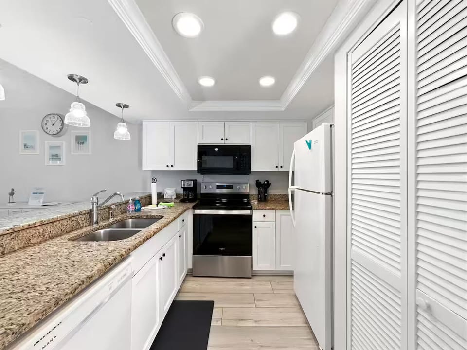 Fully equipped kitchen open to dining room and bar area.