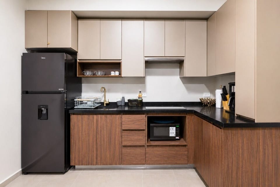 Cocina equipada con estufa, microondas, refrigerador y todos los utensilios necesarios para preparar tus comidas con facilidad.