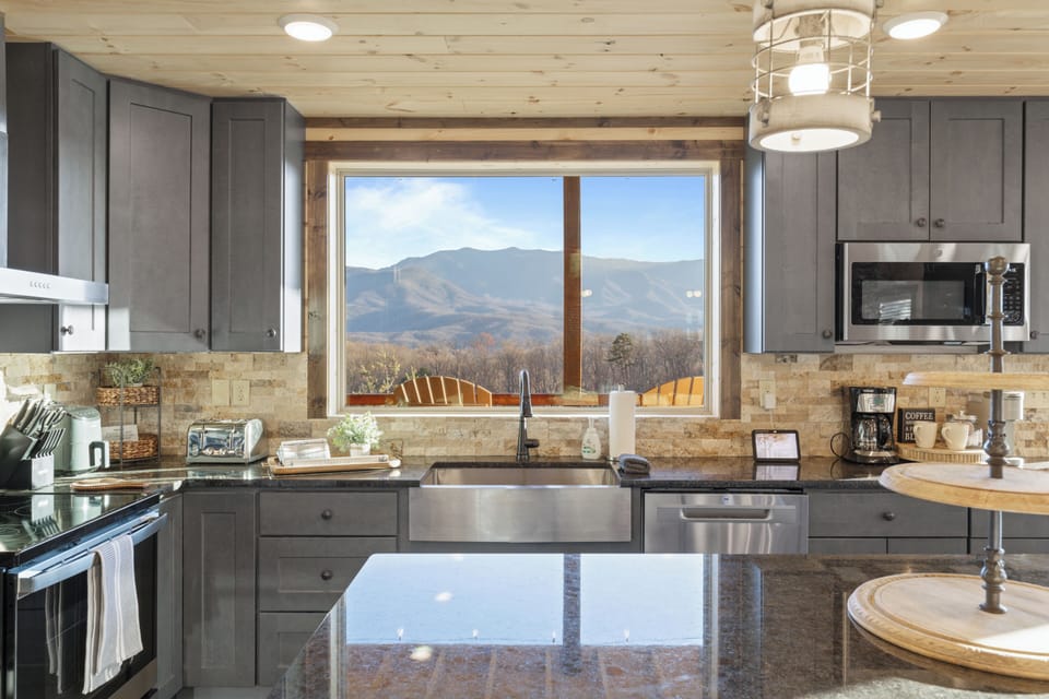 Modern mountain-view kitchen with farmhouse sink and spacious island
