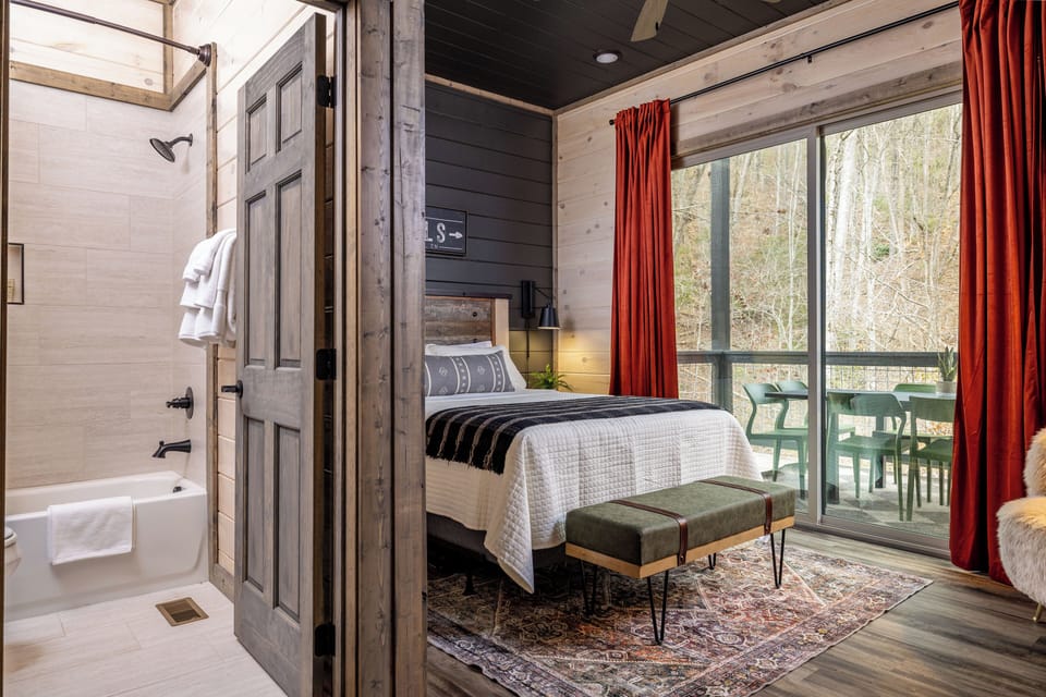 Cozy wood-accented bedroom with balcony views and adjoining bath