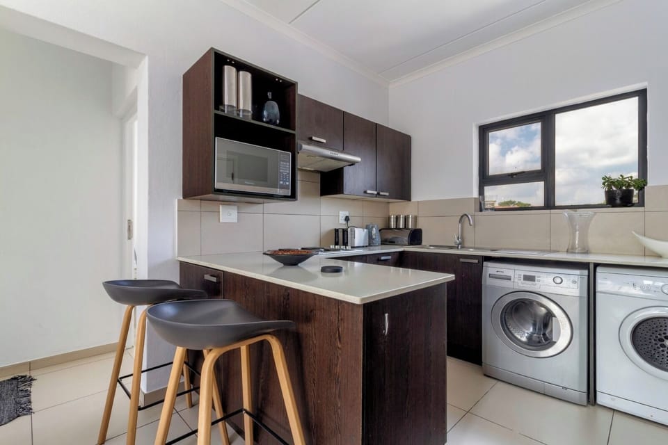 Sleek kitchen with breakfast bar, in‑unit laundry and bright window