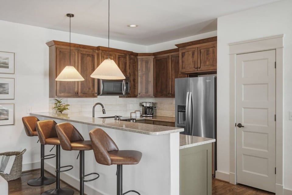 Fully equipped kitchen with stainless steel appliances. Bar countertop includes seating for 4.