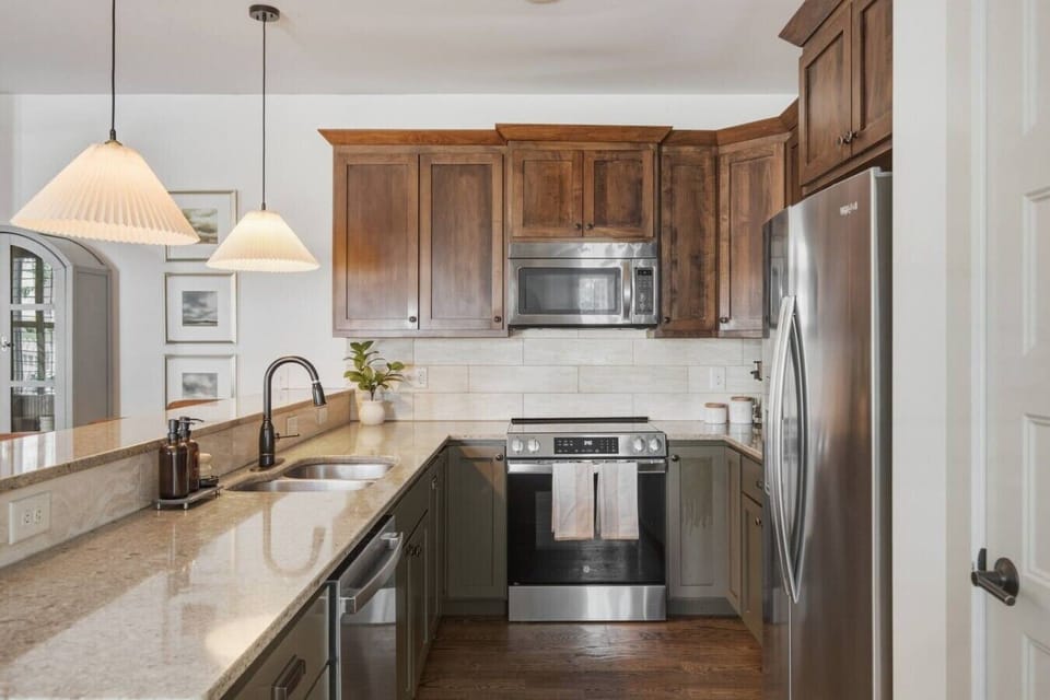 Fully equipped kitchen with stainless steel appliances. Bar countertop includes seating for 4.