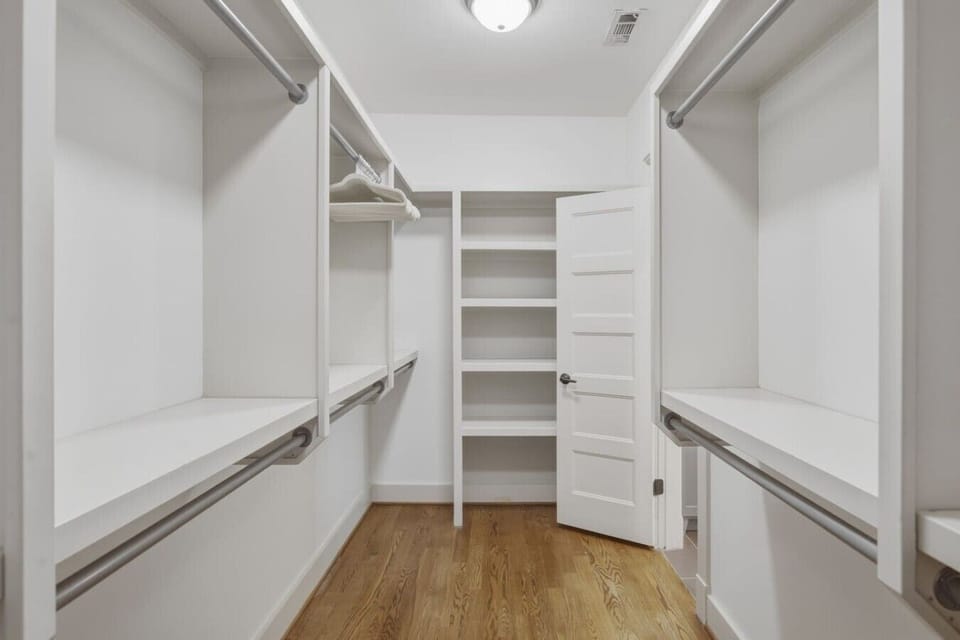 The primary suite features a king-sized bed, huge walk-in closet, ceiling fan, dresser, smart TV, and ensuite bathroom.