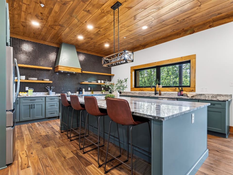 Kitchen island breakfast bar with seating for four leather-backed stools.