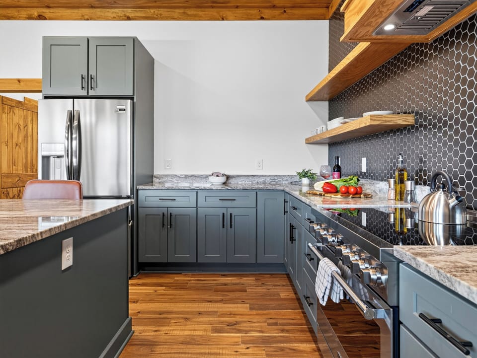 Close-up of the professional-grade gas range and open wooden shelving in the kitchen.