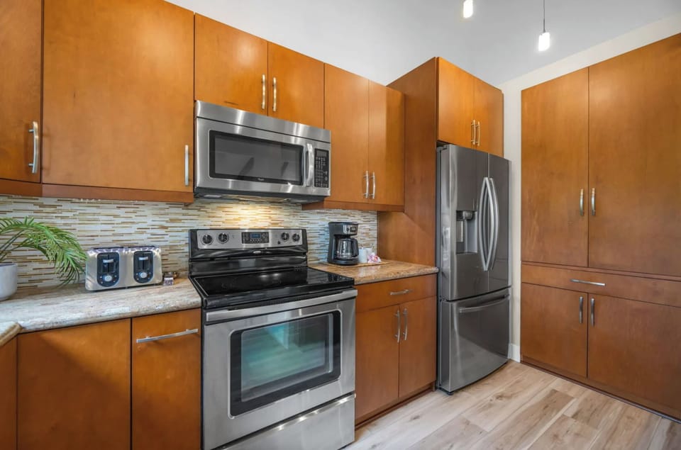 Unit 1: Cook with ease in a modern kitchen equipped with sleek stainless steel appliances, polished countertops, and ample storage.
