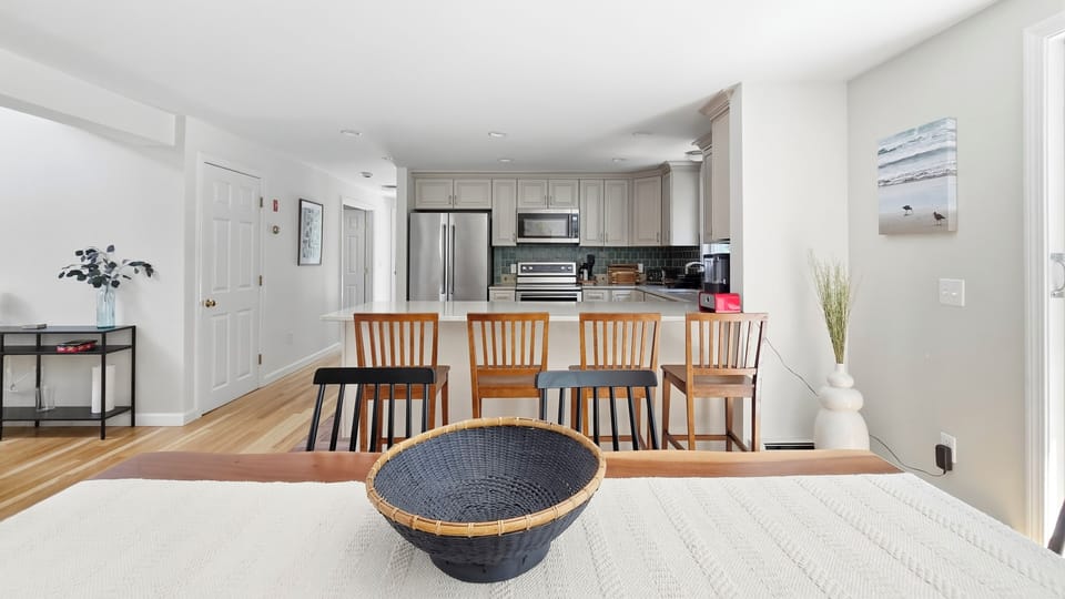 Kitchen beyond dining area with counter seating