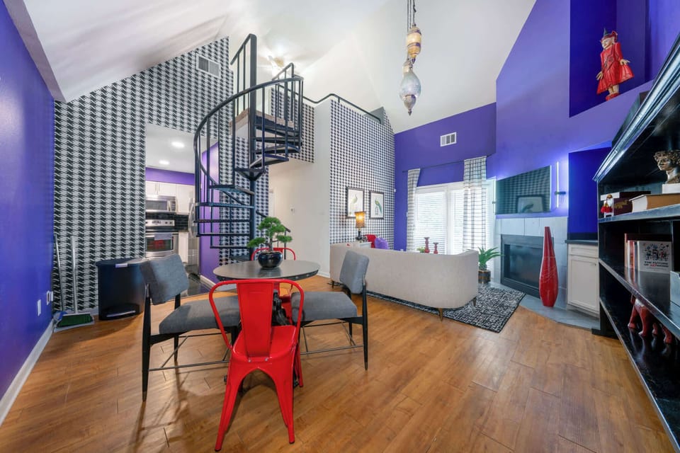 Experience modern elegance with a spiral staircase and cozy fireplace in this vibrant living space.
