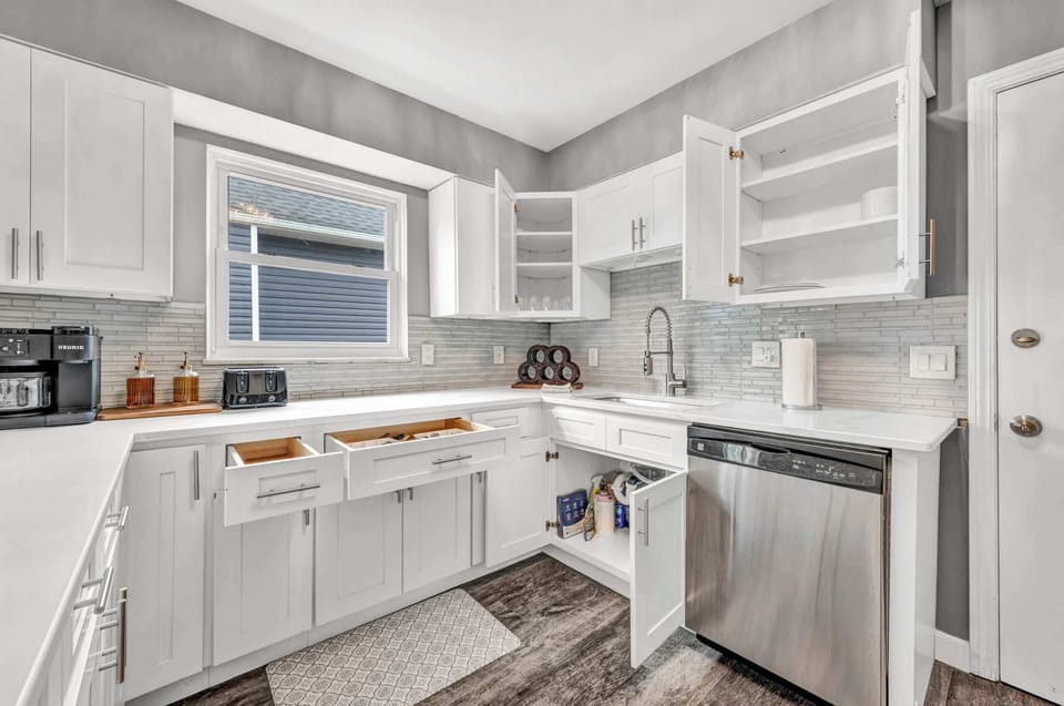 Whip up meals in the sleek white kitchen w/ warm wood floors