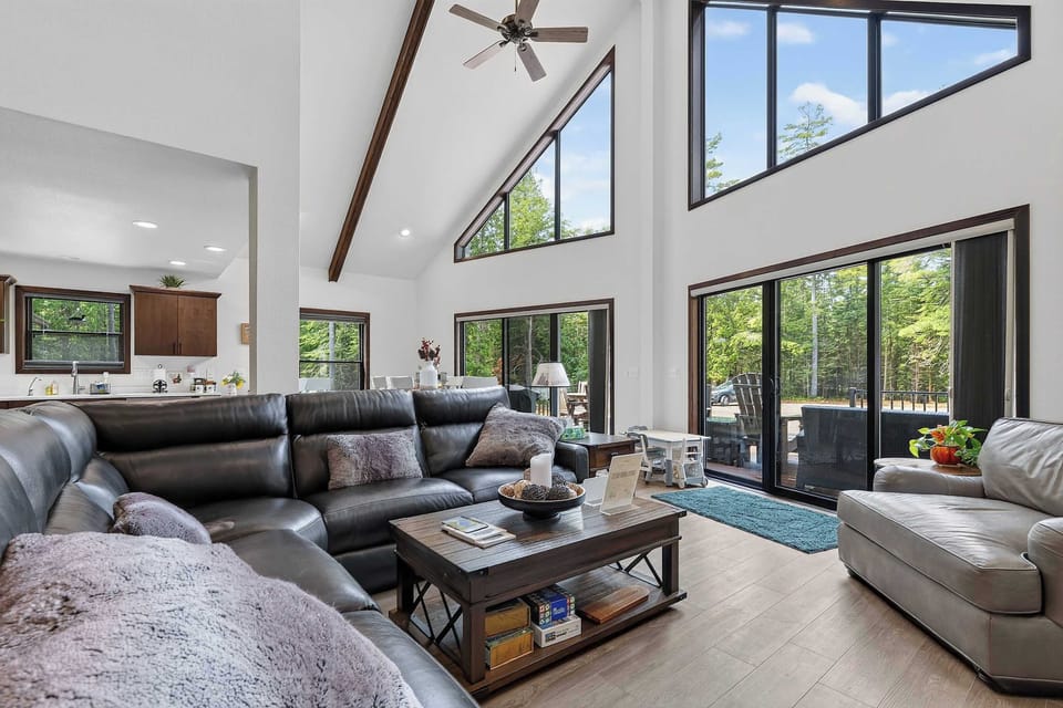Fireplace, Tv and large couch. Large Open concept living room with bright light.