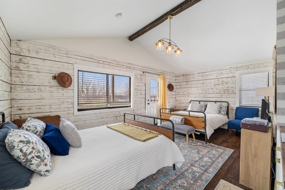 Bright farmhouse-style bedroom with two beds and cozy rustic charm