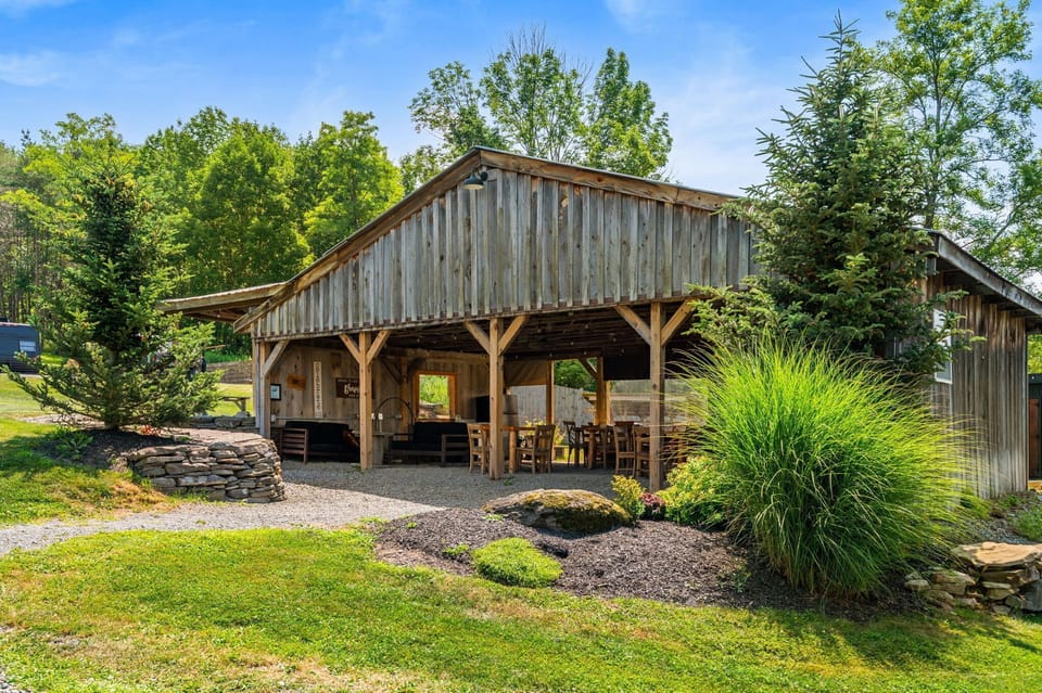 Rustic outdoor pavilion with covered seating in a peaceful scenic setting