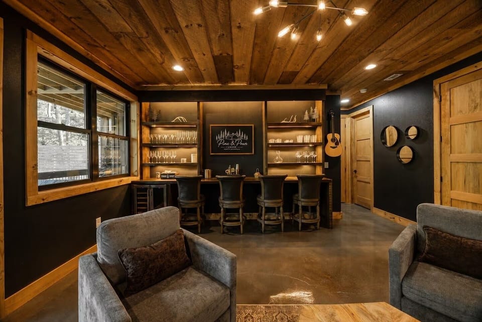 Cozy rustic lounge with custom bar, warm lighting, and upscale cabin style