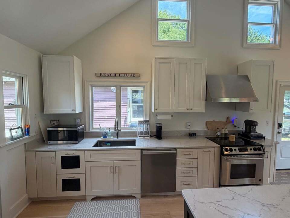 Fully stocked kitchen with full sized dishwasher, oven, and microwave