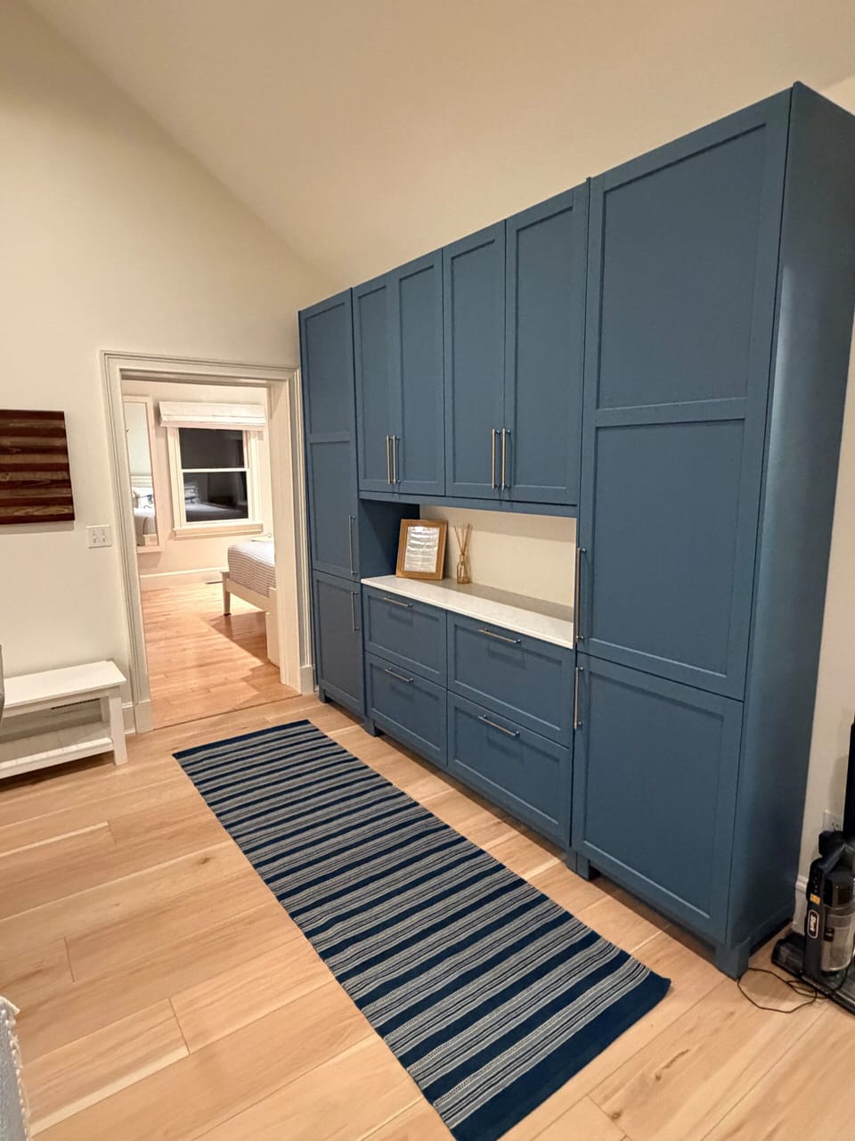 Newly installed dry bar area with additional pantry, towel, and linen storage.