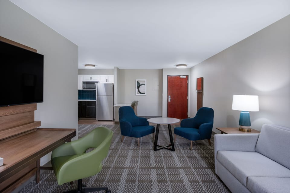 Living area with sofa, kitchenette, TV, and dining table.