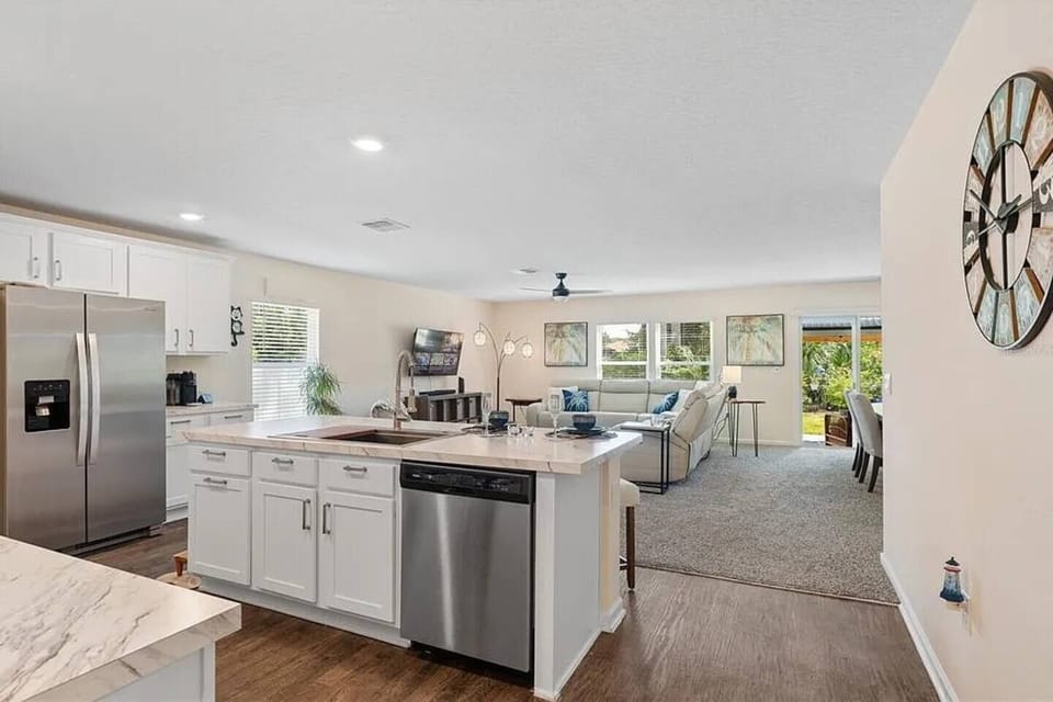 Open-concept kitchen flows seamlessly into the bright living room — great natural light, stainless appliances, dishwasher, and quartz countertops throughout.