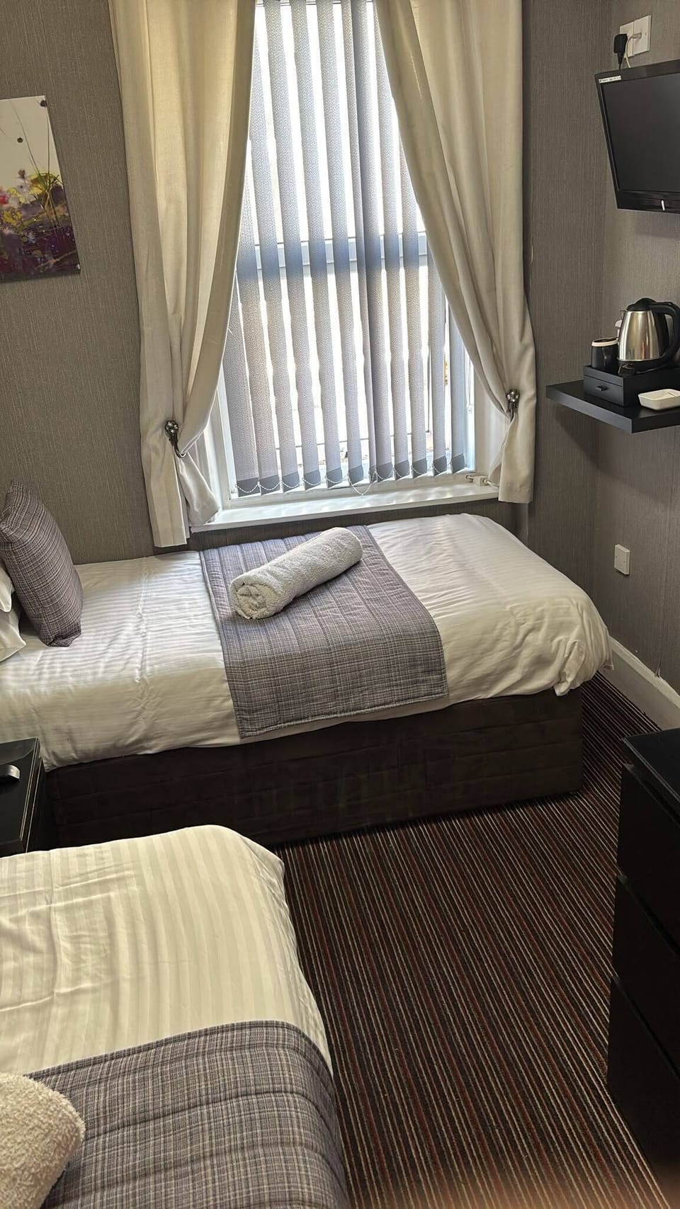 Bright twin room with tea station, TV, and clean modern styling