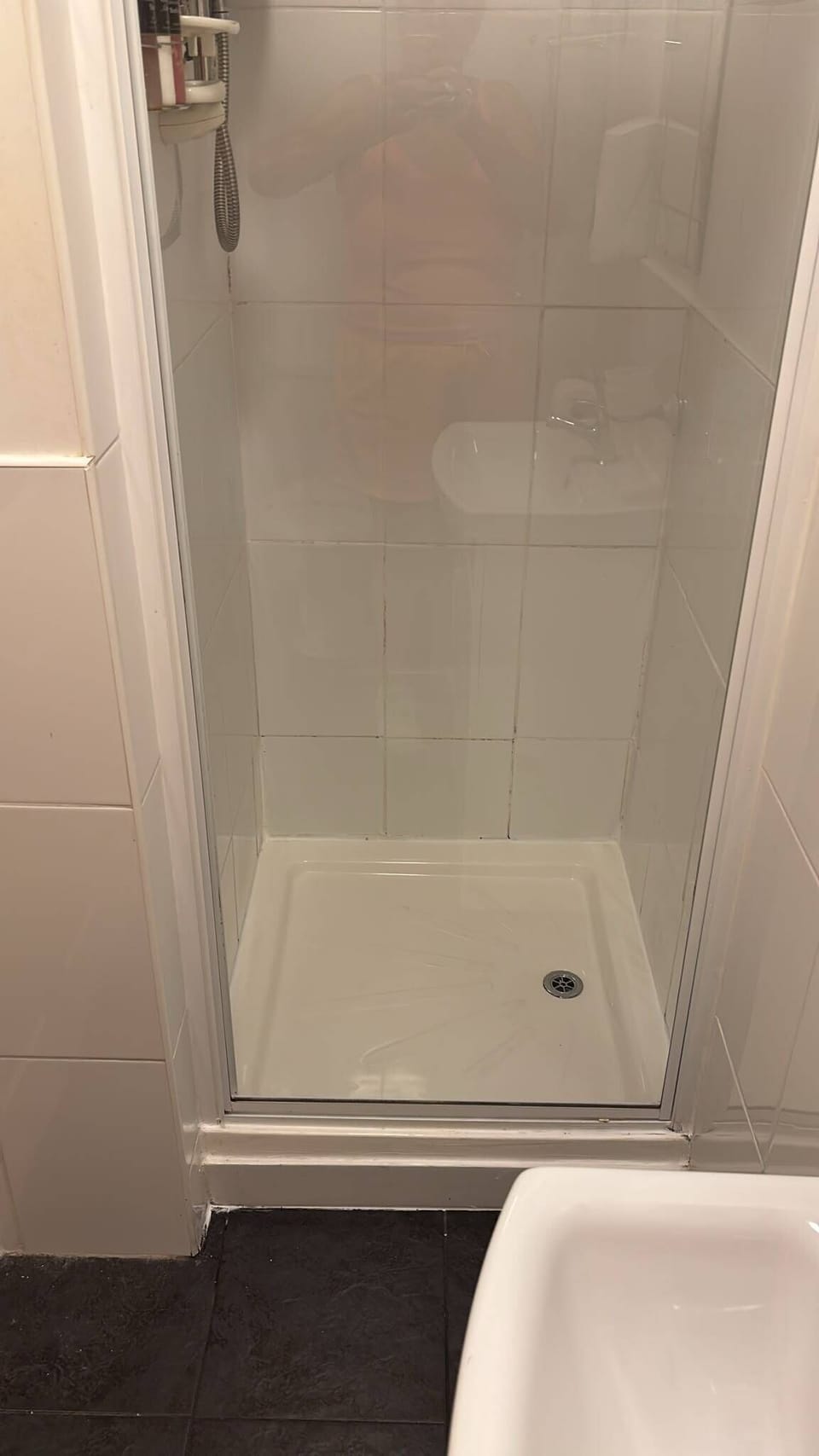 Bright tiled walk-in shower with sleek glass door and handy storage