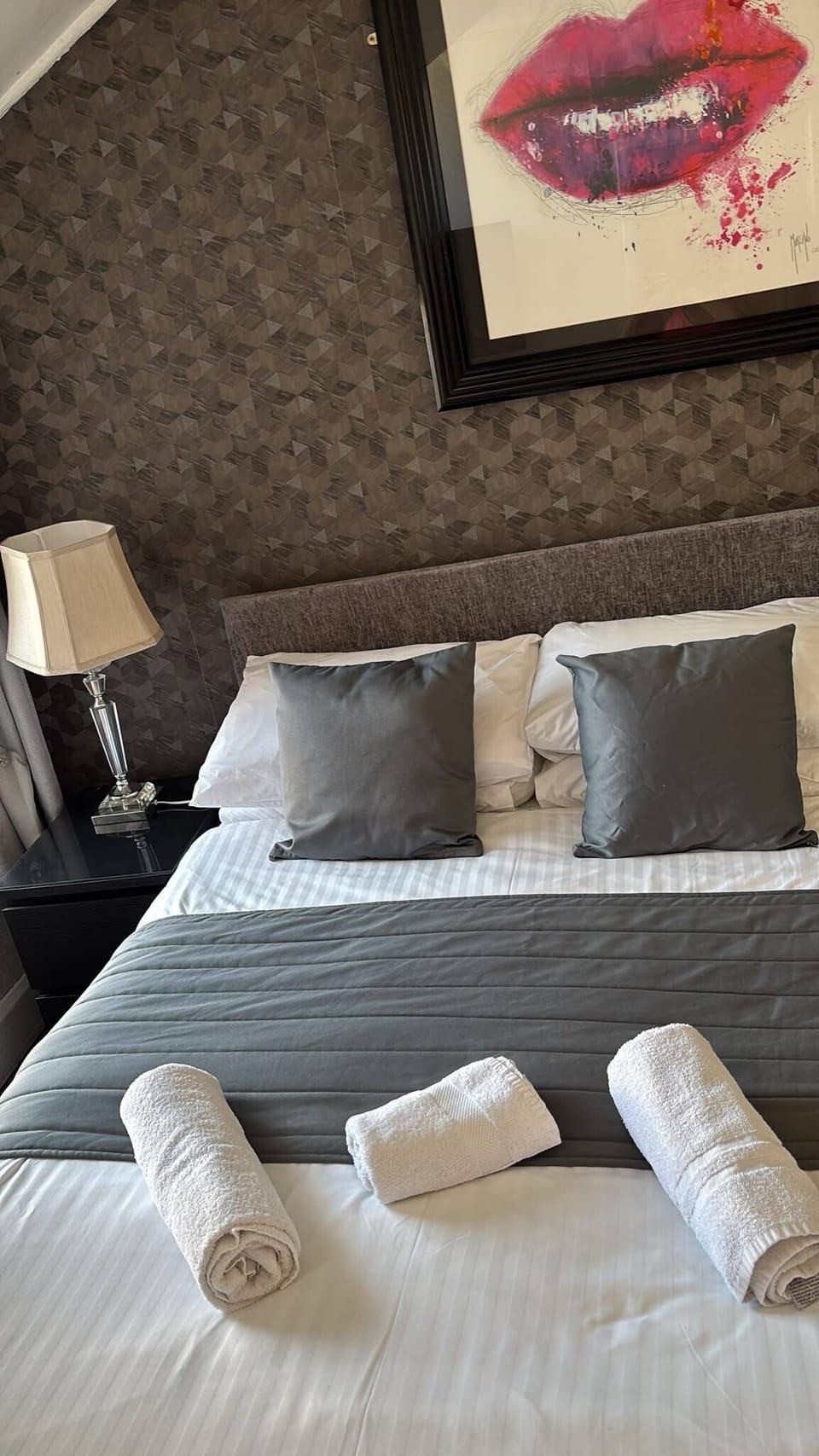 Boutique-style bedroom with luxe linens and striking modern artwork