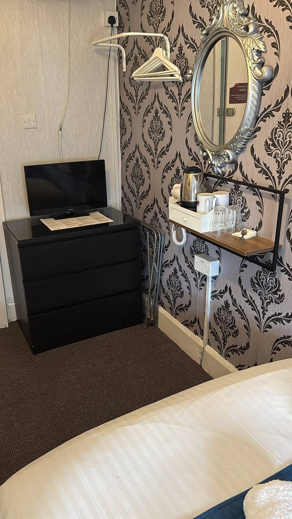 Stylish room corner with TV, tea station, and elegant mirror