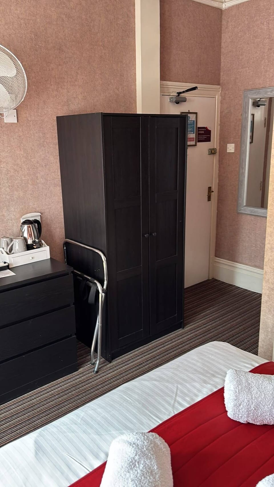 Cozy ensuite-style room with wardrobe, mirror, and in-room tea station