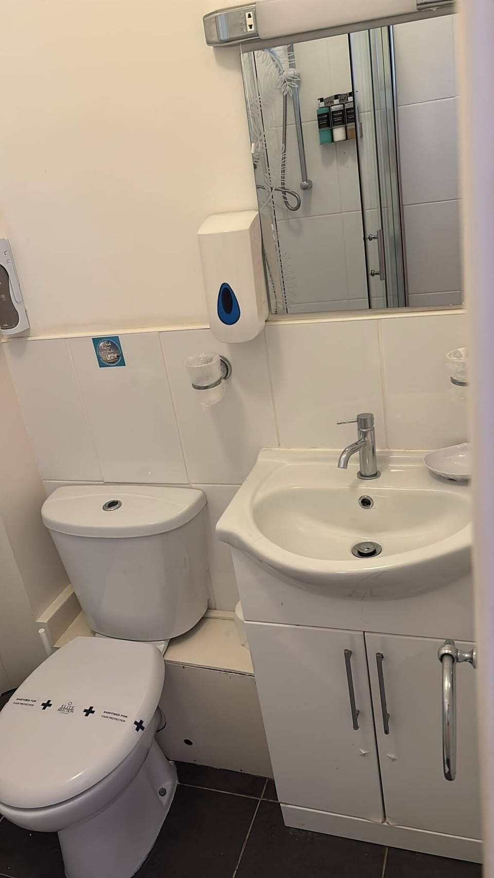 Bright, compact bathroom with modern shower and vanity storage
