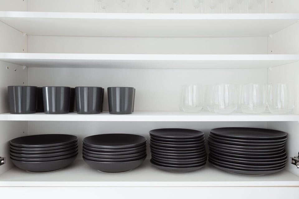 Cupboard stocked with plates, bowls and glasses for the whole group.