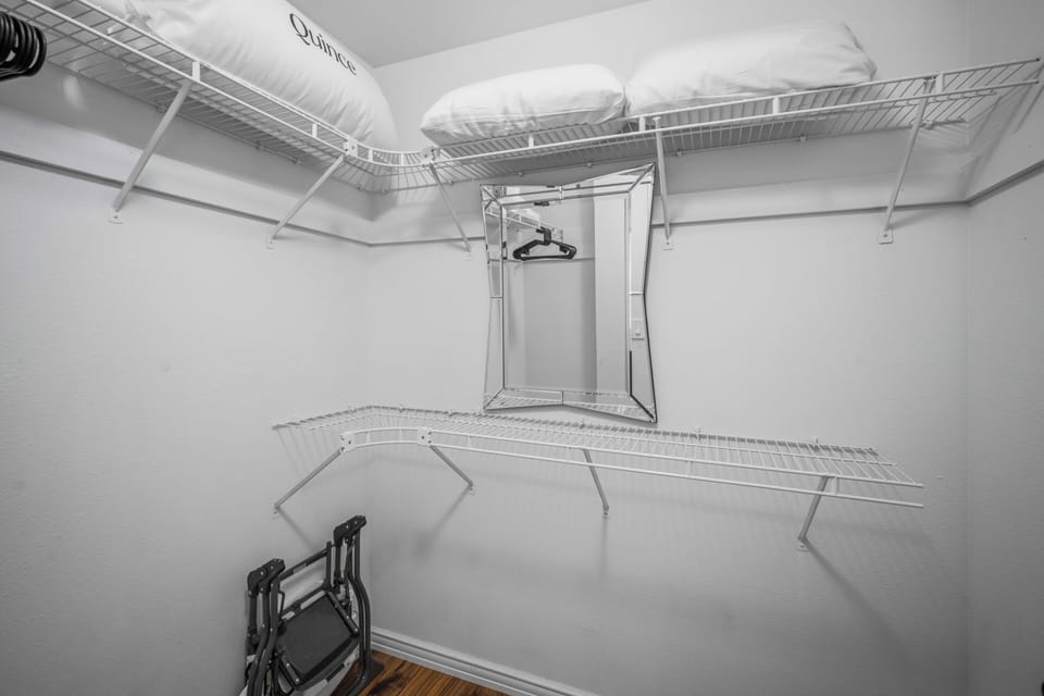 Spacious walk-in closet with wire shelving and hanging rods provides plenty of storage for all your belongings, making unpacking and settling in effortless.