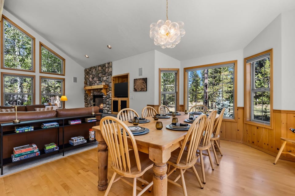 Gather around the solid wood table for meals and games, warmed by the stone fireplace and surrounded by forest views through every window.