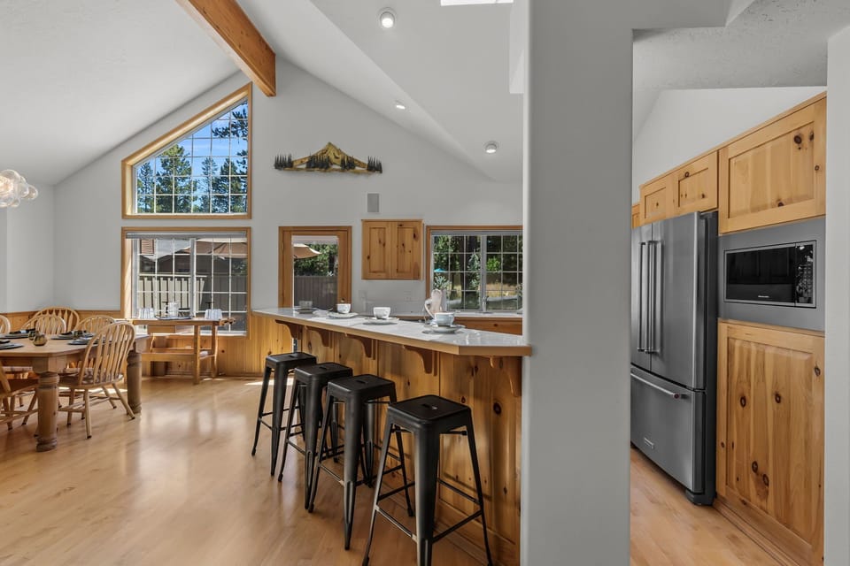 Gather around the spacious island in this bright, open kitchen with vaulted ceilings and warm wood accents. Enjoy natural light and easy access to your outdoor patio.