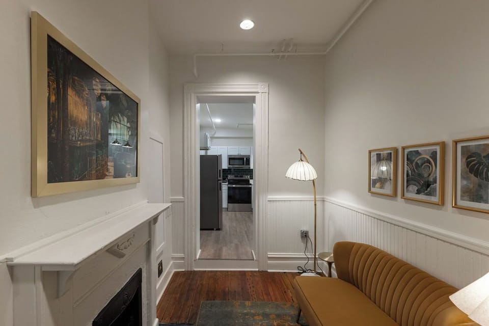 Charming lounge nook with fireplace, art, and easy kitchen access