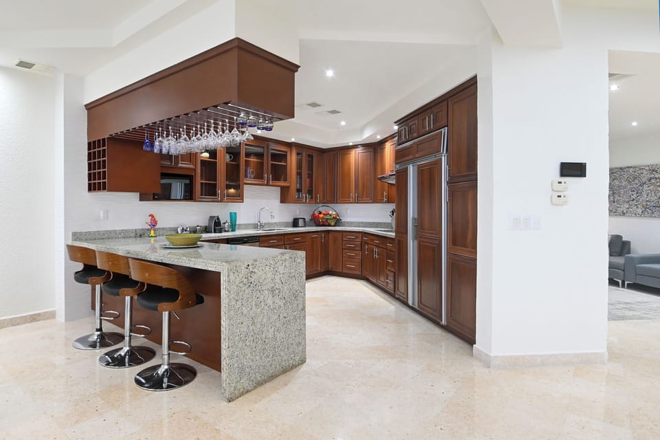 Step into your gourmet kitchen featuring rich wood cabinetry, granite countertops, and a spacious island where you can gather with friends over morning coffee or evening appetizers.