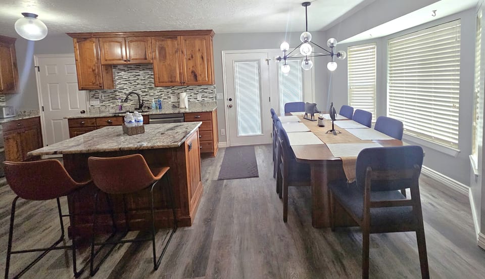 Dining area, kitchen island with barstools, and 8 person dining table.