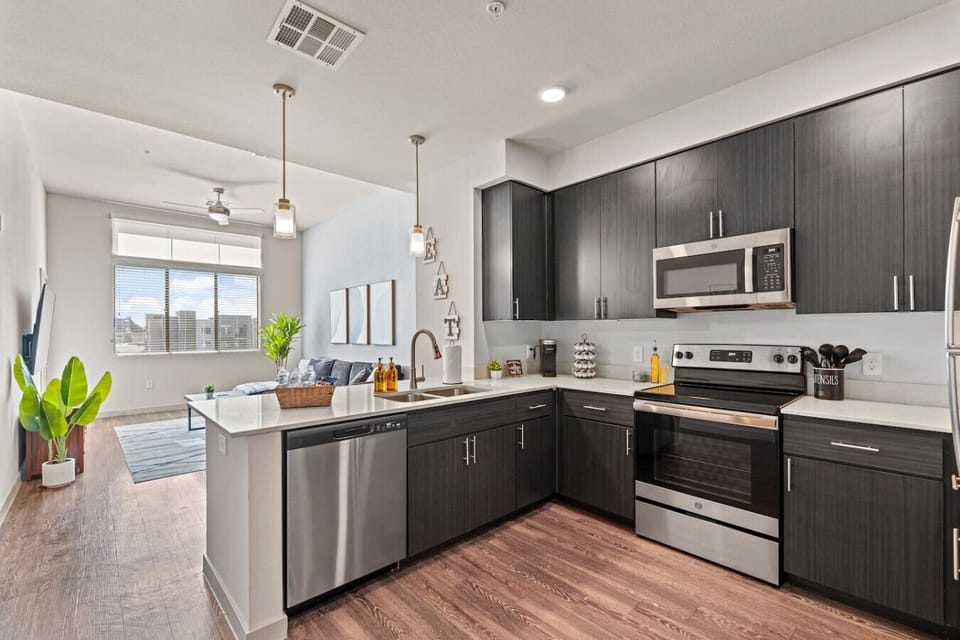 This fully equipped kitchen has everything you need to prepare and enjoy home-cooked meals, including stainless steel appliances, a coffee station, and all the necessary cooking supplies.