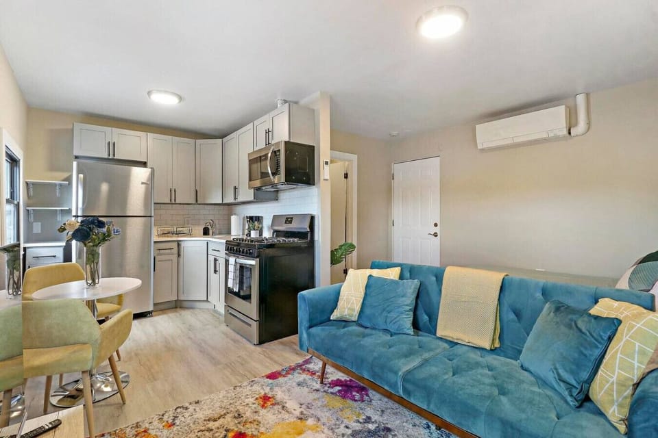 This living room offers a comfortable blue couch perfect for lounging, a smart TV for entertainment, high-speed Wi-Fi for staying connected, and a selection of board games for some friendly competition.