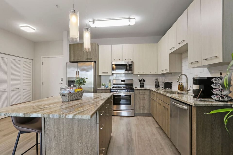 This stylish space features a fully equipped kitchen with stainless steel appliances.