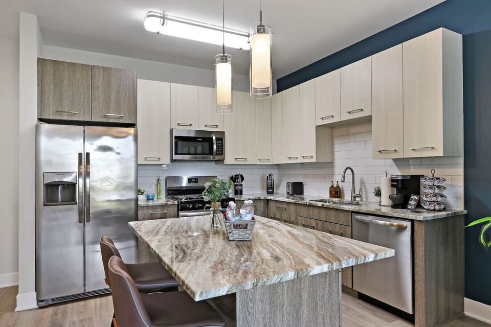 This stylish space features a fully equipped kitchen with stainless steel appliances.