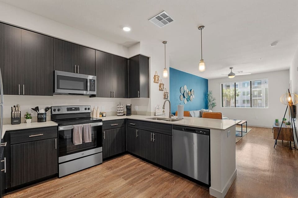 This fully equipped kitchen has everything you need to prepare and enjoy home-cooked meals, including stainless steel appliances, a coffee station, and all the necessary cooking supplies.