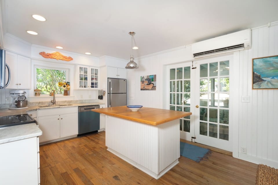 Bright, airy kitchen with a warm wood island invites you to cook, gather, and savor every moment—your perfect blend of comfort and coastal charm.